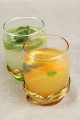Lemonade in glasses on fabric background close-up