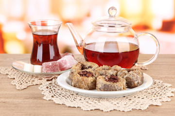 Sweet baklava on plate with tea on table in room