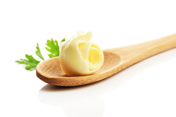 Butter curl on wooden spoon, isolated on white