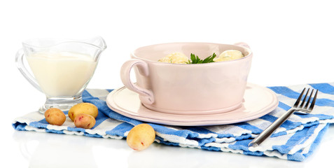 Tender young potatoes with sour cream and herbs in pan isolated