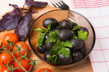 Olives in a bowl on a wooden surface