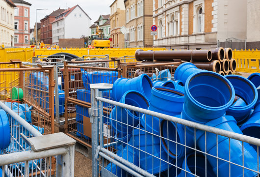 Kunststoffrohre und Tonrohr gelagert auf einer Baustelle