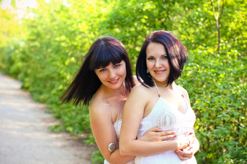 Naklejka premium Two happy brunette in a summer park
