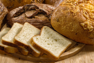 Assortment of baked bread on wood table.  Хлеб