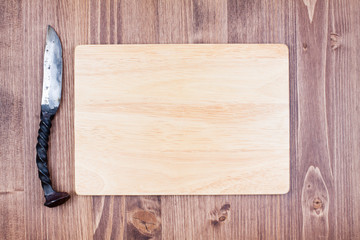 Wooden board blank with old knife on wood background