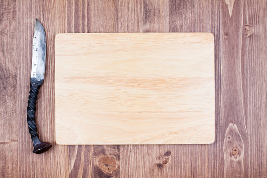 Wooden board blank with old knife on wood background