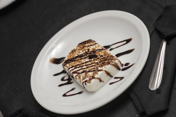 Helado con chocolate en plato de ceramica blanco y cuchara