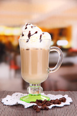 Layered coffee in glass on table on bright background