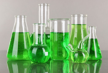 Test-tubes with green liquid on gray background