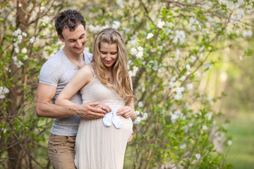 Fototapeta premium Young pregnant couple outdoors in spring