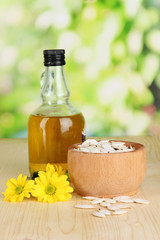 Useful pumpkin seed oil on wooden table on natural background