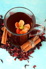 Herbal tea in glass cup, on color wooden background