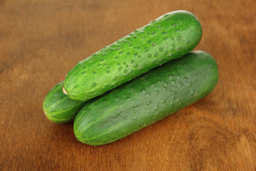 Tasty green cucumbers on wooden background
