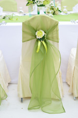 Wedding chair decorated with green color and flower.
