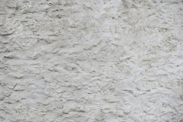Texture of the gray roughly plastered wall