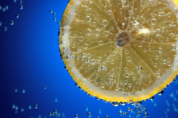 Slice of fresh lemon in water with air bubbles