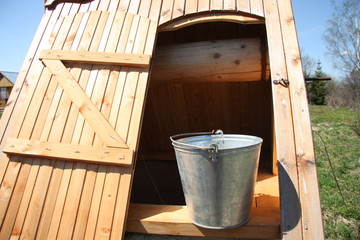 Vintage wooden well with a bucket in the countryside