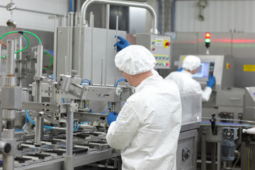 two workers at production line in plant