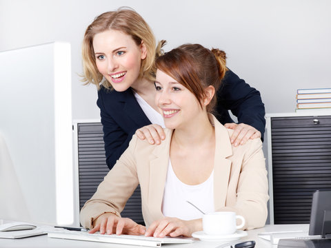 Two business women surching on the internet in the office
