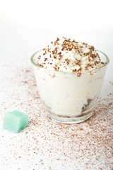 White cup of whipped cream with chocolate, on a white background