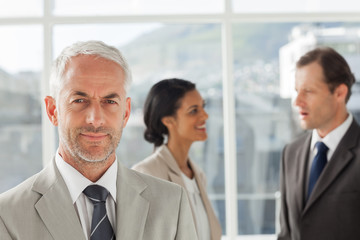 Businessman standing in front of colleagues speaking together