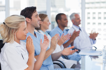 Medical team clapping hands - Powered by Adobe