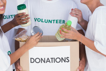 Volunteers putting food in donation box