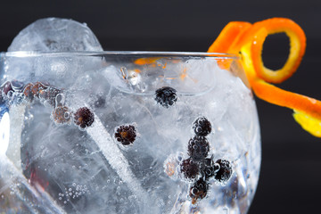 Gin tonic cocktail macro closeup with juniper berries