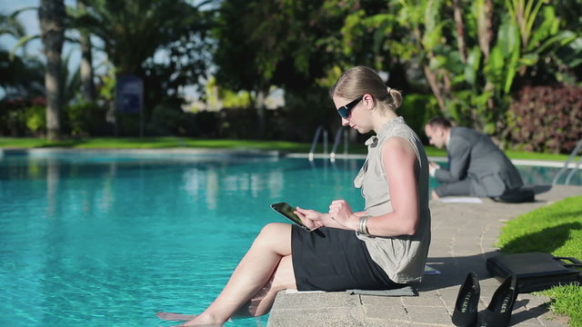 Businesswoman relaxing by the poolside after work