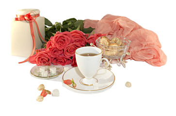 The white cup, orange roses, slices of sugar are isolated