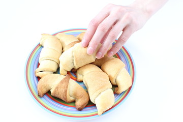 Hand taking a fresh croissants on white background