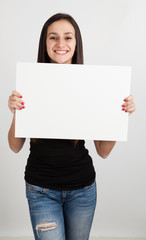 Young woman holding a white board