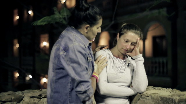 Young woman comforting her friend in the evening, steadicam