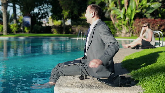 Businessman relaxing after work by the swimming-pool