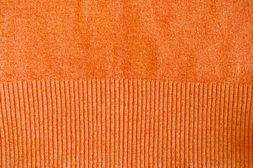 orange knitted wool sweater closeup background