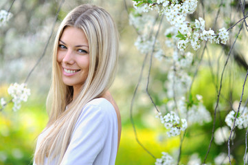 Portrait of attractive beautiful blonde woman in green blooming