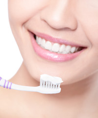 smiling woman cleaning teeth with toothbrush