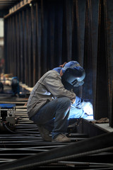 welder with protective mask welding metal and sparks