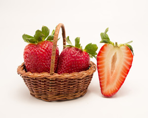 Isolated  cut strawberries and two in basket