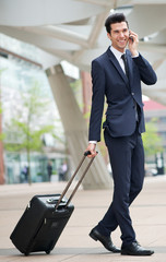 Traveling businessman talking on phone outdoors