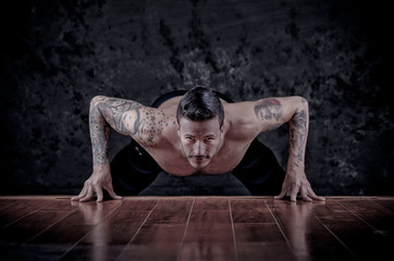 Fototapeta na wymiar Portrait of a healthy young guy doing push ups