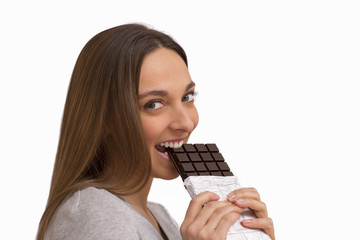 Young woman eating chocolate on white background