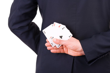 Businessman holding playing cards behind his back.