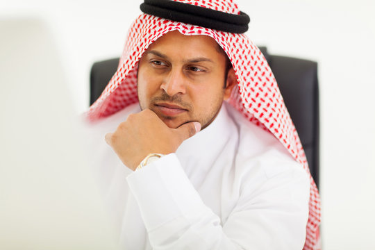 arabic businessman looking at computer screen
