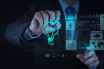 businessman hand draws lightbulb with new computer interface