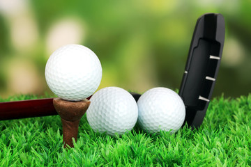 Golf ball and driver on green grass outdoor close up