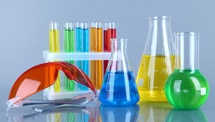 Test-tubes with colorful liquids on gray background