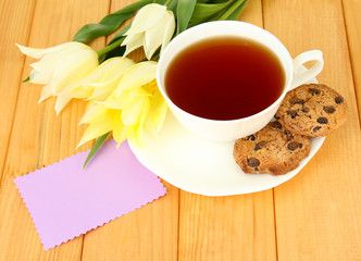 Composition of tulips and cup with some drink,