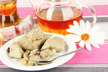 Tasty halva with tea on table close-up
