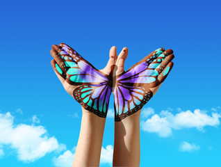 Hand en vlinder hand schilderen, tatoeage, over een blauwe lucht